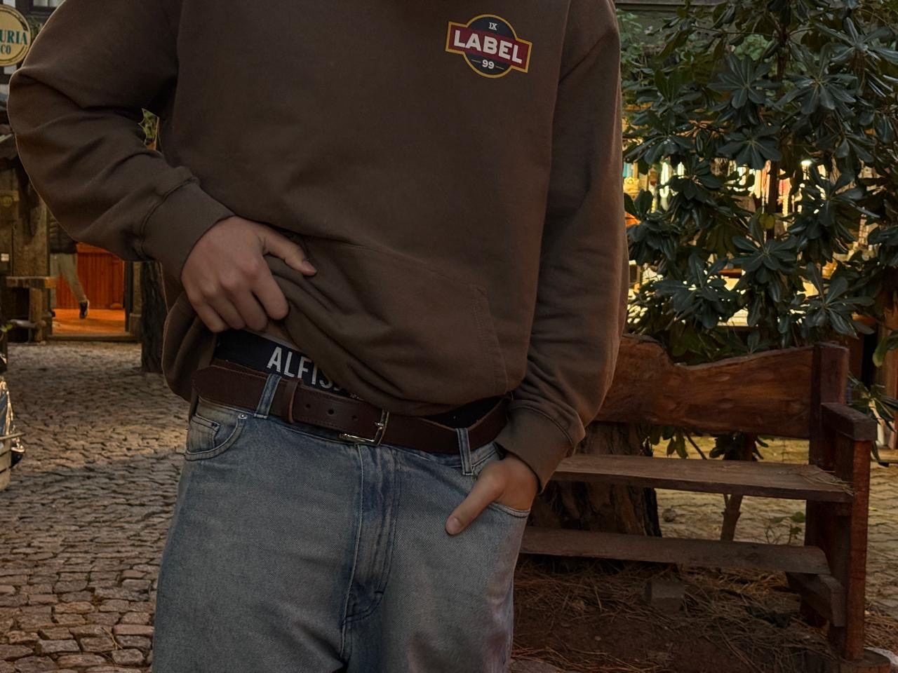 Cinturón de cuero marrón con jean y buzo